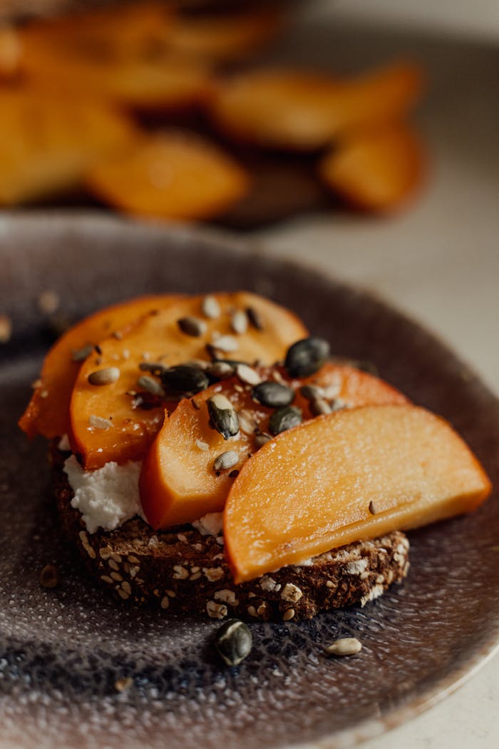 our-stories Delicious persimmon toast topped with seeds and cheese for a healthy breakfast option.