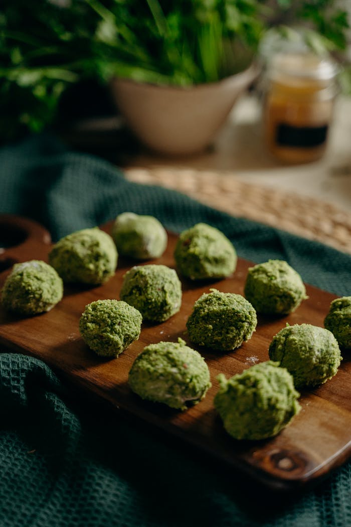 service-06 Freshly prepared green herb falafel on a wooden board, perfect for healthy vegan meals.